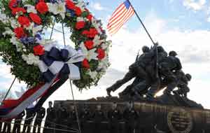 2012年2月23日、硫黄島上に国旗を掲揚した67周年で祖国のために彼らの生命を捧げた海兵隊員たちの追悼記念日における花輪贈呈中に直立でヘンダーソンホール海兵隊員たちが立つ。ヘンダーソンホールHQMC、H&S大隊の指揮官アイラ・M・チーサム大佐は、海兵隊戦争記念碑、同様に式典に参加したジョセフ・M・ダヴェンポート三世少佐、海兵隊戦争記念碑財団の創設者、会長及び常務取締役ジェームズ・P・ドノヴァン海兵隊伍長（退役）、MCWMF取締役スティーブ・コミンスキー、そして、マイケル・ケスラー海兵隊中佐（退役）の足下に花輪を置いた。